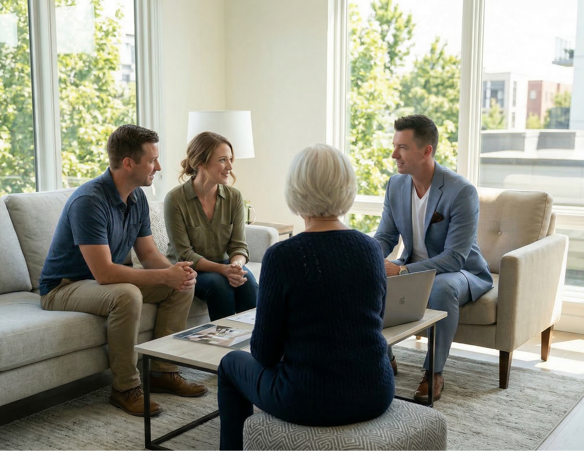 Real estate agent discussing home sale options with a senior homeowner and adult children during a family meeting.